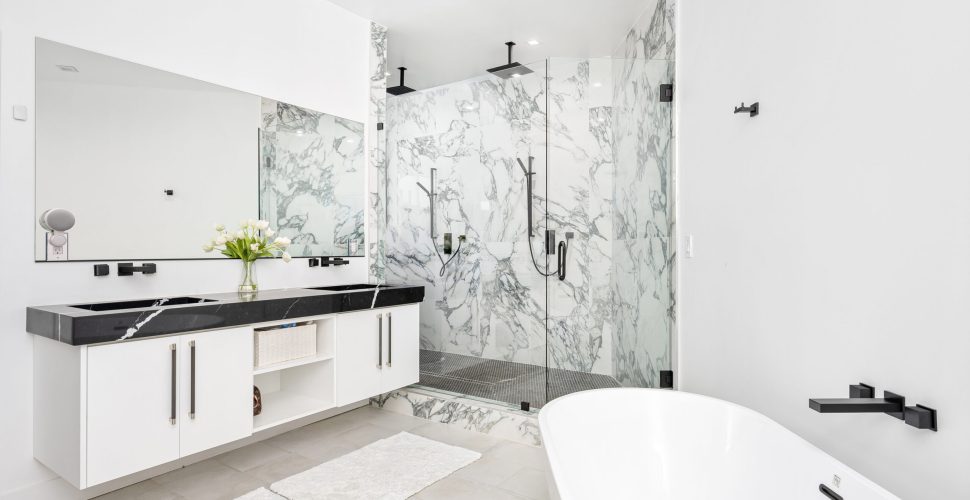 A modern white bathroom with a luxurious marble countertop and a bathtub