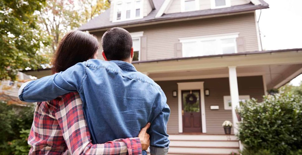 Rear View Of Loving Couple Looking At House